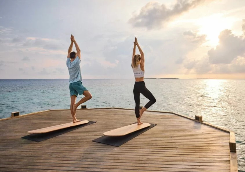 Pessoa em postura tranquila de yoga num ambiente acolhedor